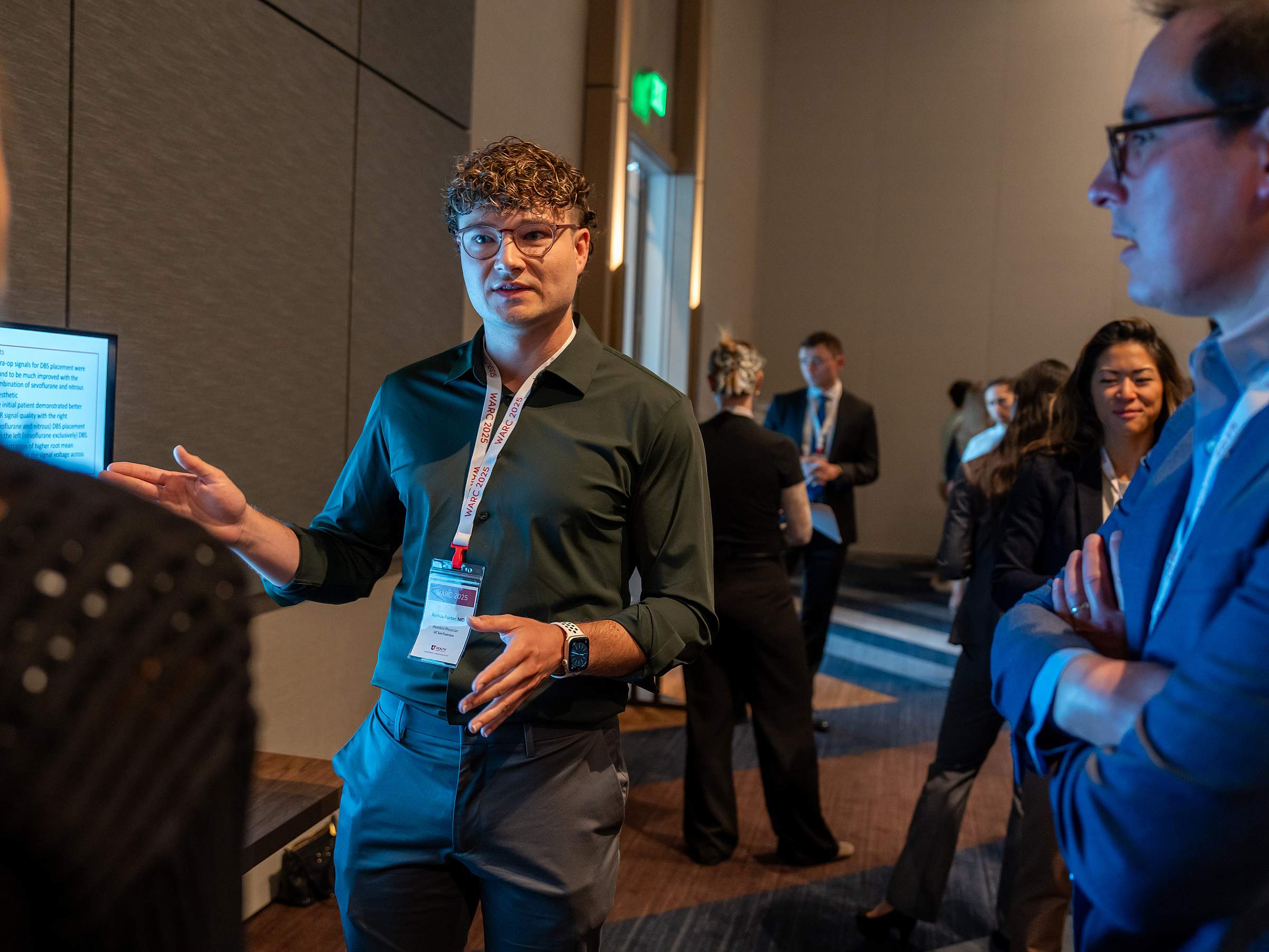 A resident presents his poster at WARC while judges and other conference attendees look on.