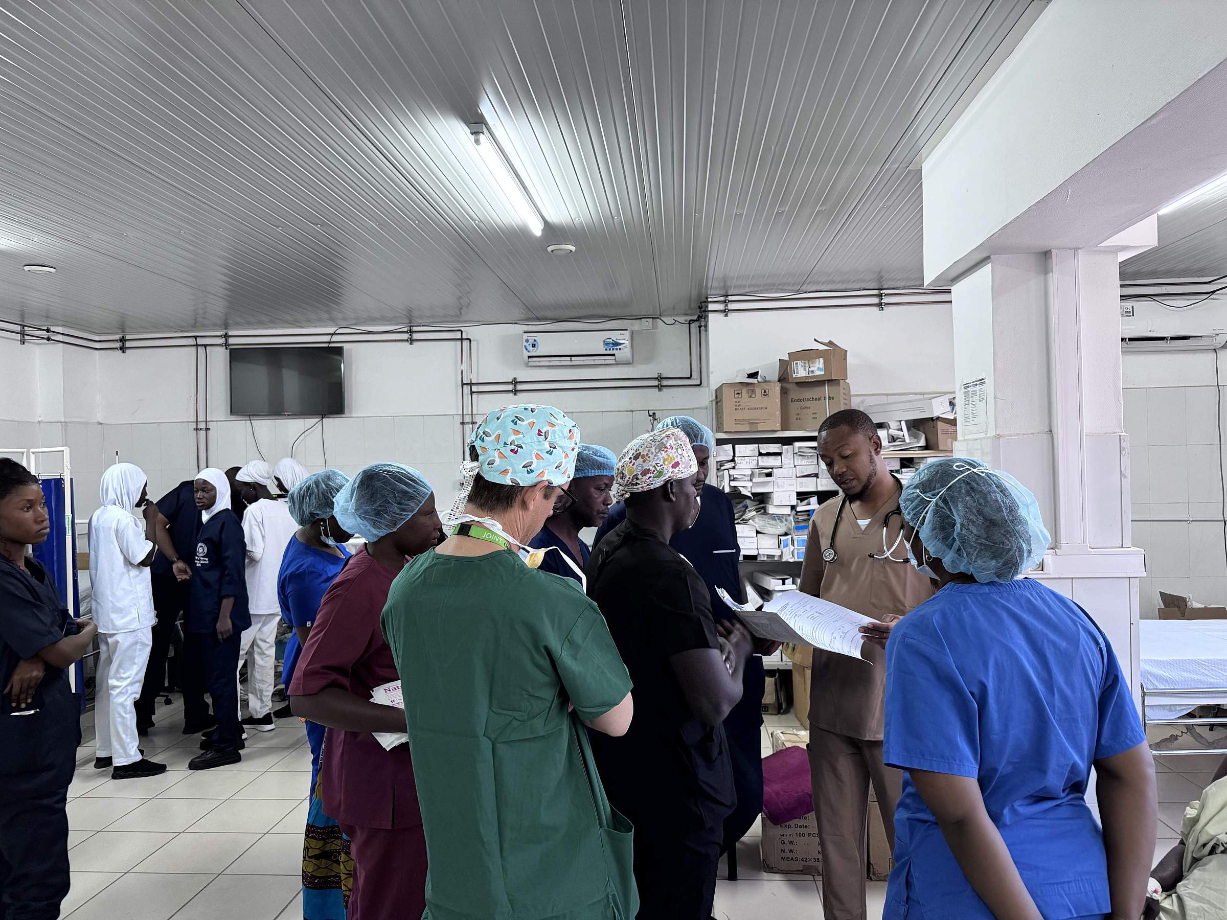 Doctors and nurse anesthesiologists gather in scrubs and protective gear.