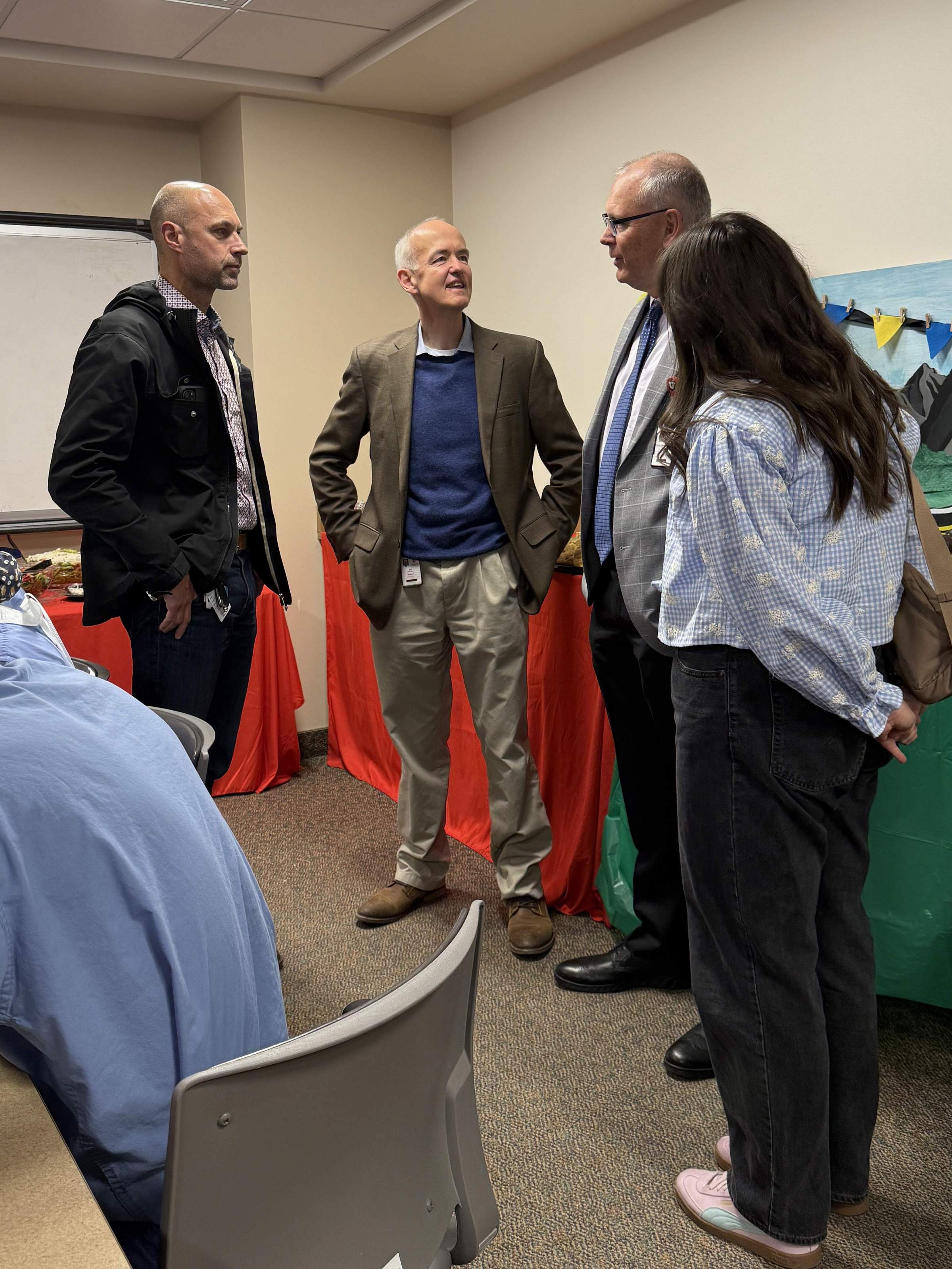 Dr. Ken Johnson speaks with party attendees and his daughter.