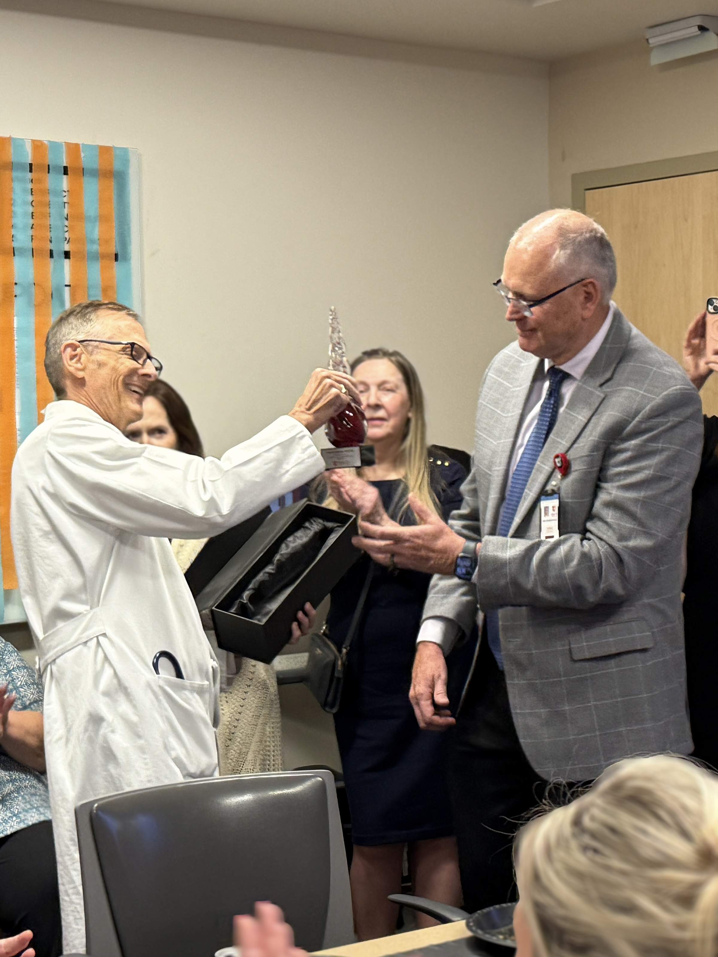 Dr. Talmage Egan presents Dr. Ken Johnson with a glass trophy.